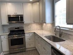 an empty kitchen with white cabinets and granite counter tops, stainless steel stove top oven and dishwasher