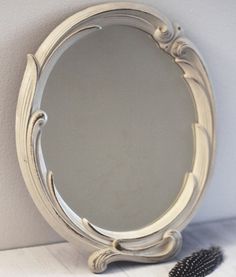 a mirror sitting on top of a table next to a brush