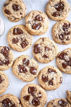 chocolate chip cookies on a baking sheet next to a glass of milk