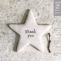 a white ceramic star ornament that says thank you