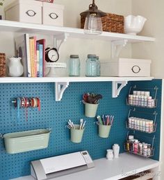 a sewing machine and craft supplies on a shelf in a room with blue pegboard