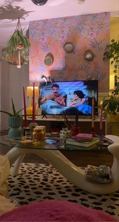 a living room filled with furniture and a flat screen tv sitting on top of a table