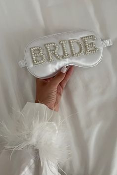 a bride's hand holding a white bag with the word bride on it