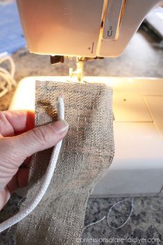 someone is using a sewing machine to sew on some burlocked material