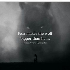 a person standing in front of a black and white photo with the words fear makes the wolf bigger than he is