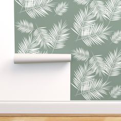 a wallpaper with palm leaves on it and a white roll in front of the wall