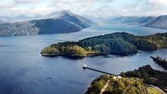 an aerial view of several islands in the water with trees on both sides and mountains to the side