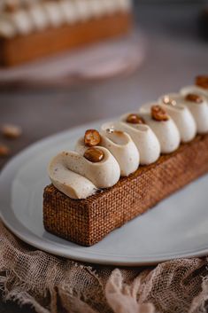 a piece of bread with bananas and nuts on it sitting on a plate next to a napkin