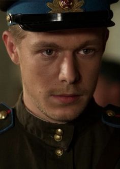 a man in uniform looking at the camera with an intense look on his face and shoulders