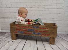 a baby sitting in a wooden box reading a book with the words, if there's you read