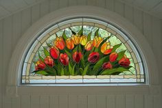 a stained glass window with red and yellow tulips