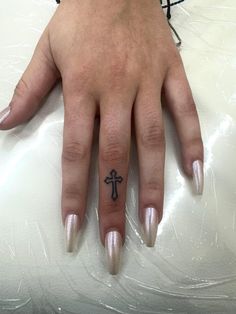 a woman's hand with a cross tattoo on it