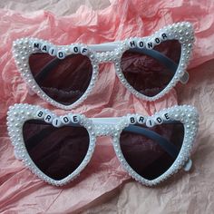 two pairs of sunglasses with the words bride and maid of honor written on them, sitting next to each other