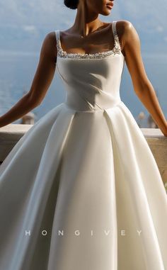 a woman in a white dress standing on a ledge