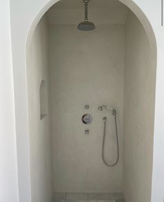 the shower is in an archway between two walls, and there is no curtain on it