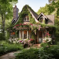 a small house with lots of flowers growing on it's roof and windows, surrounded by greenery