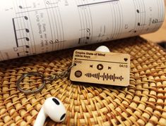 a wooden keychain sitting on top of a table next to an earphone