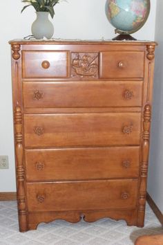 a wooden dresser with a globe on top