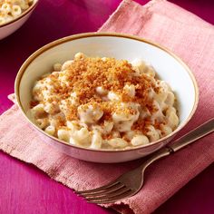 a white bowl filled with macaroni and cheese on top of a pink cloth