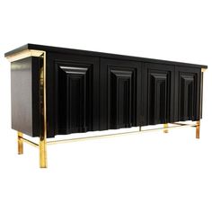 a black and gold sideboard with four doors on it's sides, in front of a white background