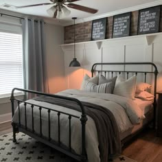 a bedroom with a bed, ceiling fan and two lamps on either side of the bed