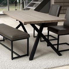 a wooden table with two chairs and a bench in front of it on a carpeted floor