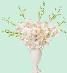 a white vase filled with lots of flowers