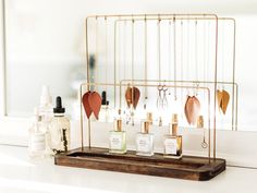 a wooden tray with bottles on top of it next to a mirror and other items