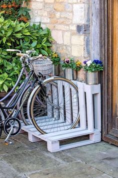 a bicycle parked next to a wooden crate with flowers in it and the words, slotted in place