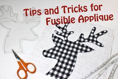 a pair of scissors sitting on top of a piece of fabric with the words tips and tricks for fushible applique