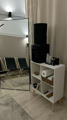 a white shelf with some items on top of it and a mirror in the background