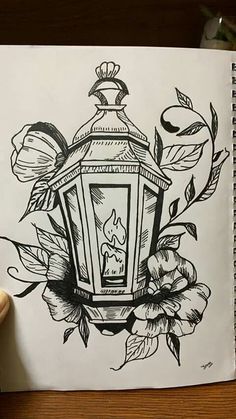 a black and white drawing of a lantern surrounded by flowers