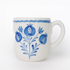 a blue and white coffee cup with flowers on it