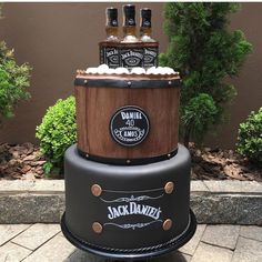 there is a cake made to look like a barrel with three bottles sitting on top