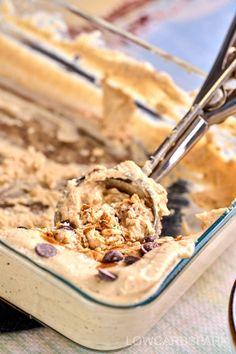 an ice cream dish with chocolate chips in it and a spoon scooping out some ice cream