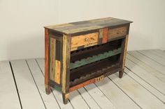 an old wooden wine rack with several bottles on it's sides and two drawers