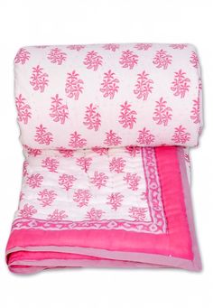 the pink and white blanket is folded up on top of it's own pillow