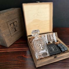 an open wooden box with two bottles and lighters inside on top of a table