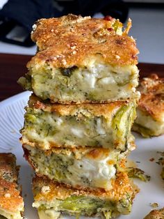 four pieces of broccoli lasagna stacked on top of each other in a white plate