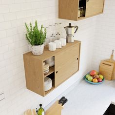 a kitchen counter with plates and cups on it, next to a potted plant