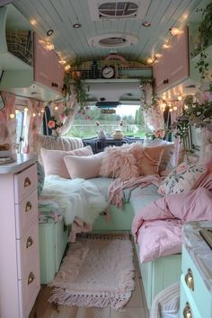 the interior of an rv decorated in pastel pinks and greens with lots of lights