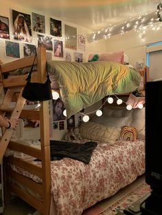 a woman standing in front of a bunk bed with lights strung from the ceiling above it