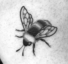 a black and white photo of a bee on the back of a woman's stomach