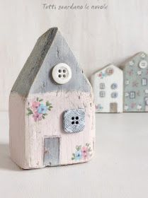 three small wooden houses with buttons on the front and back of each house, one has a button in it's center