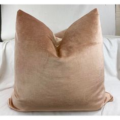 a brown pillow sitting on top of a white bed