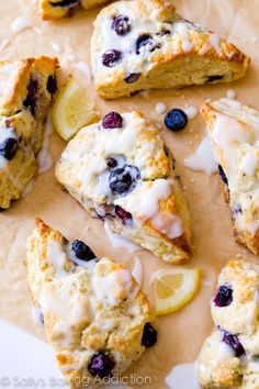 blueberry scones with lemon and icing are on a cutting board next to a woman's face