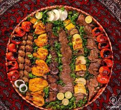 a platter filled with meat and vegetables on top of a red table cloth,