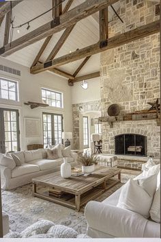 a living room filled with furniture and a fire place next to a stone wall covered in windows