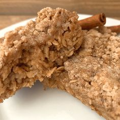 two pieces of food on a plate with cinnamon sticks