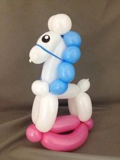 an inflatable balloon dog sitting on top of a pink and blue ring toy